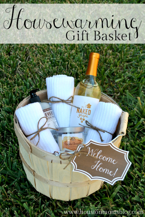 Housewarming Gift Basket. A photograph of a gift basket with a bottle of wine, towels, a scented candle and hand soap and a label that reads welcome home. 