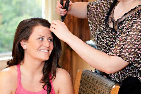 A woman getting her hair styled at home.