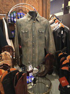 A button down shirt displayed in a store selling cowboy apparel. 