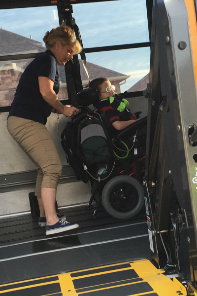 child in wheelchair gets lifted onto school bus