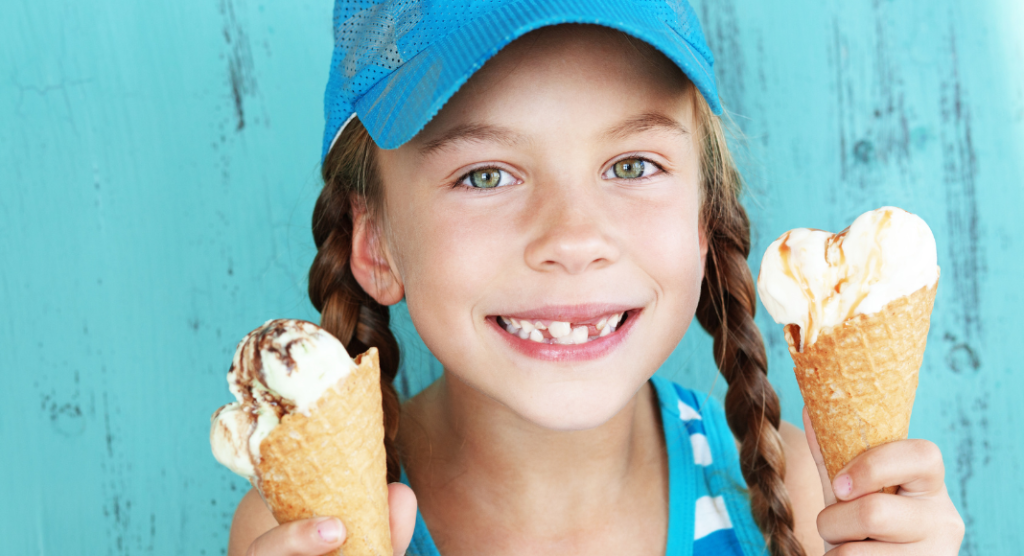 young girl holds two ice cream cones