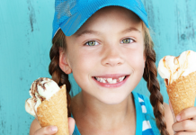 young girl holds two ice cream cones