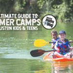 Two diverse little boys kayaking down a beautiful river