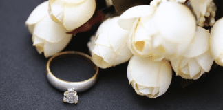 Why I Won’t Raise My Children in the Purity Culture That Raised Me Fabric white roses next to a diamond ring.