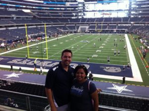A husband and wife at a football stadium. 
