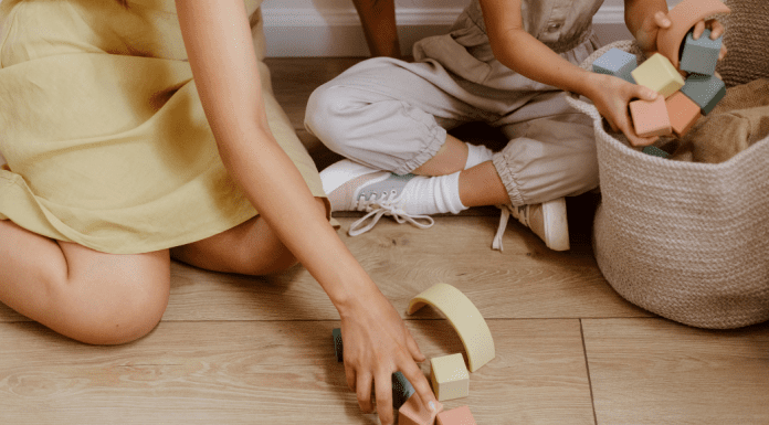 mom and child tidy home by cleaning up blocks