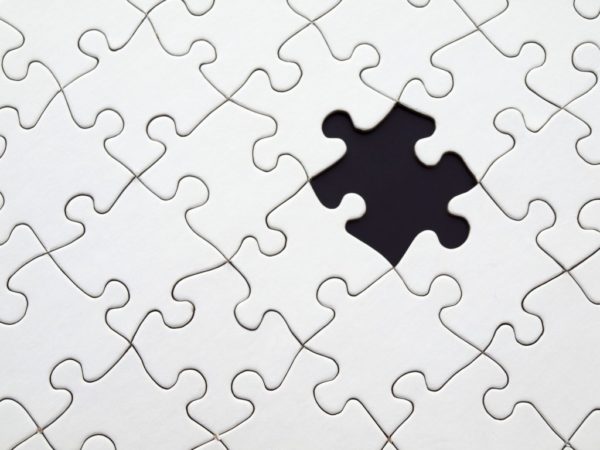 A white puzzle with one black piece.