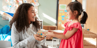 child hands teacher a gift