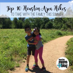 Top 10 Houston Area Hikes To Take With The Family This Summer. A photograph of Two smiling children hugging each other on a trail. Logo: Houston Moms Blog. 
