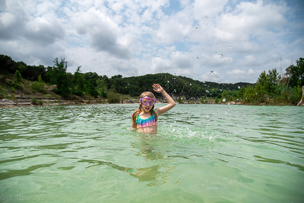 A child standing in a lake in Wimberley.