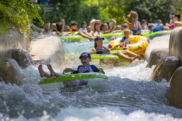 A child sitting in a tube on a river at New Braunfels Tubing.