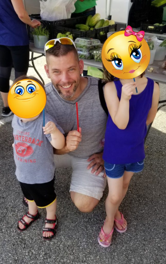 foster children with faces covered pose with foster father 