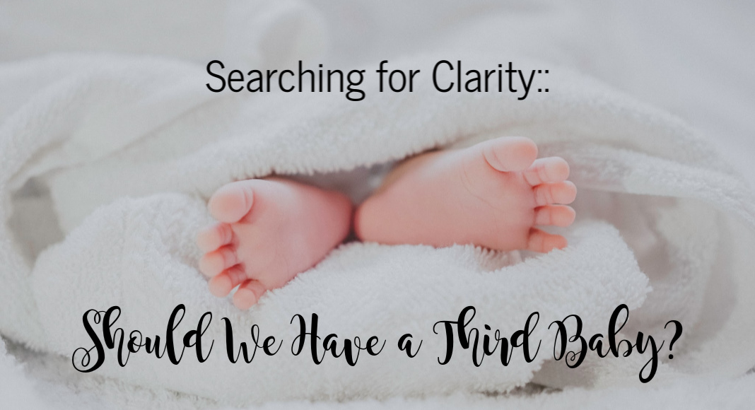 Searching for Clarity: Should We Have a Third Baby? A photograph of a baby's feet extending out of a fluffy blanket.