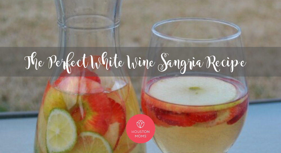 The Perfect White Wine Sangria. A pitcher and glass of white sangria with limes, strawberries, and apples. Logo: Houston moms blog.