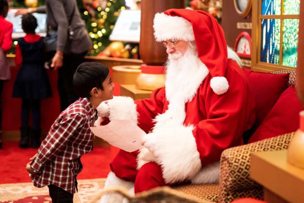 A child smiling at Santa Claus. 