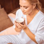 Delighted nice woman holding a cup of tea