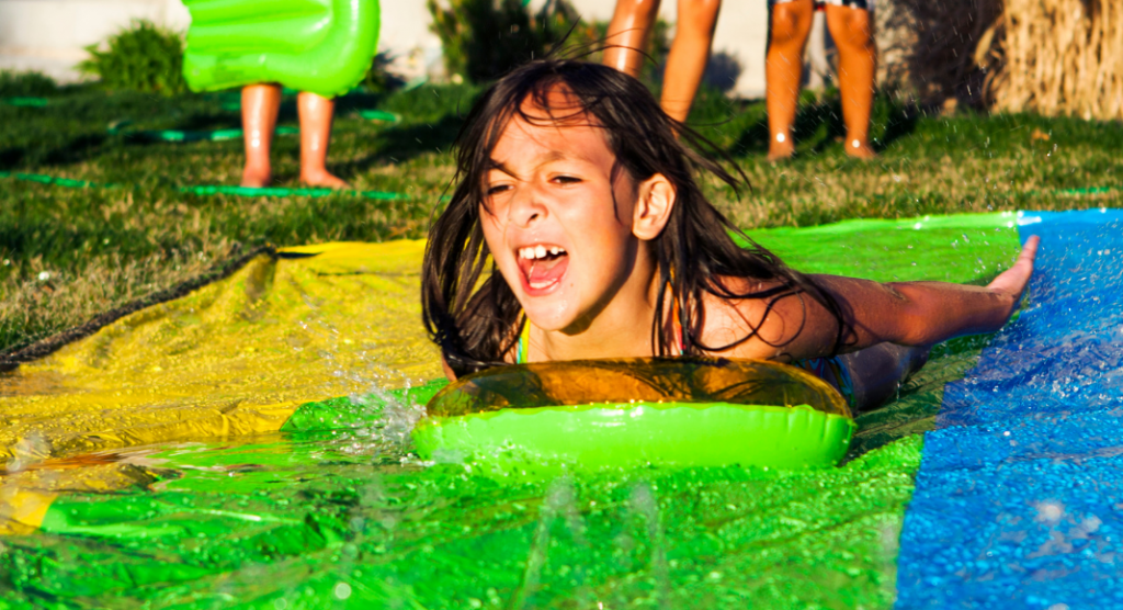 A child using a slip and slide. 