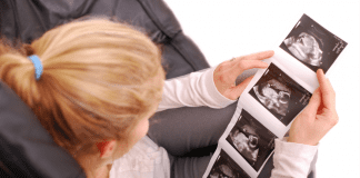 A woman looking at ultrasound images of a fetus.