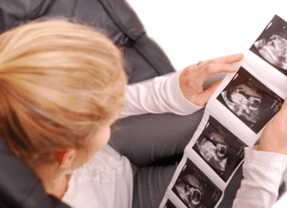 A woman looking at ultrasound images of a fetus.