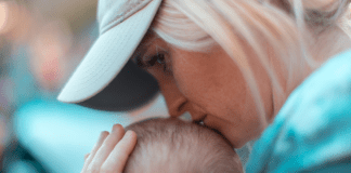 A woman kisses a baby's head.