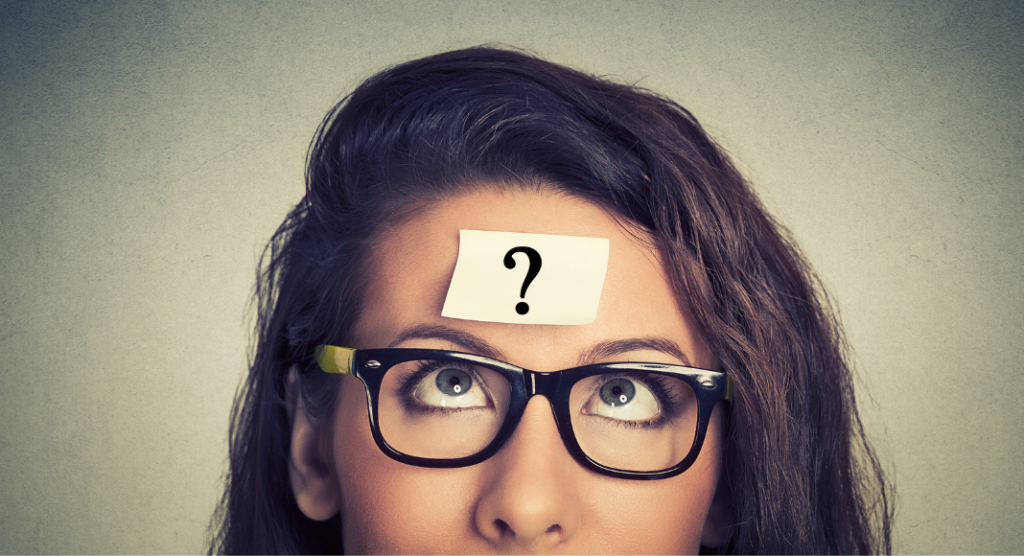 woman with glasses with post it with question mark on her forehead
