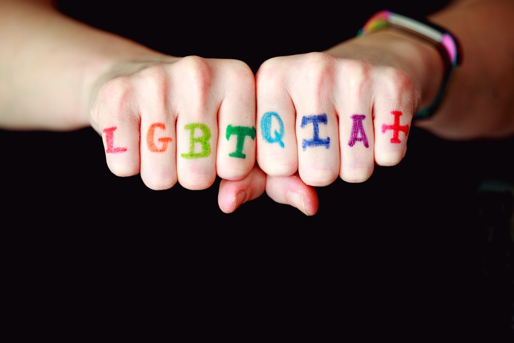 L G B T Q I A plus spelled on a person's fingers. 