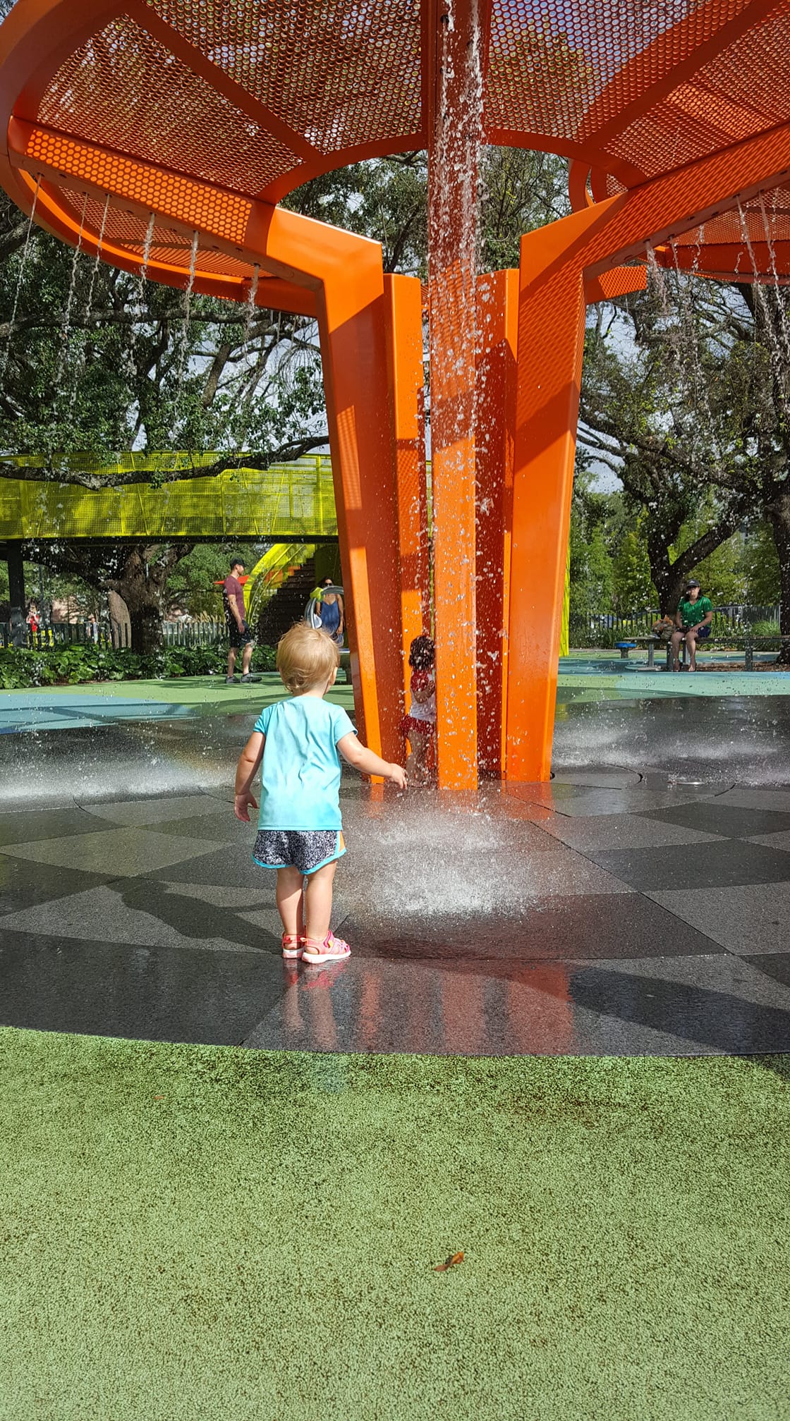 young toddler plays in a splash pad