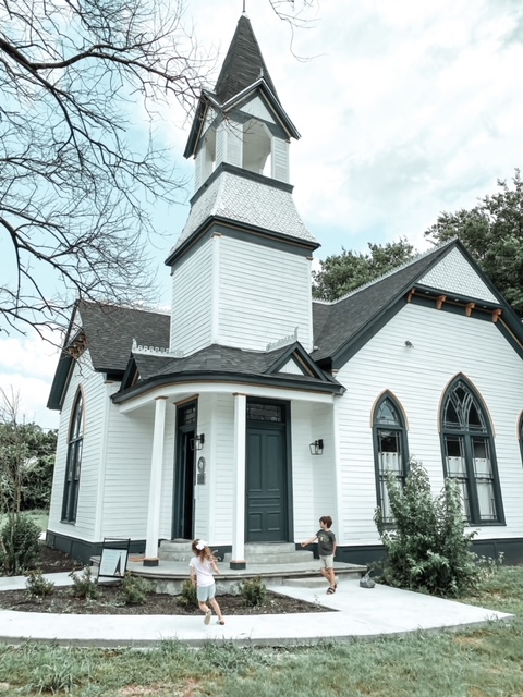 Two children playing outside an old church. 