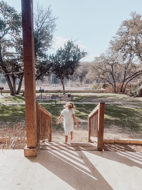 A child walking down a ramp leading to a park. 