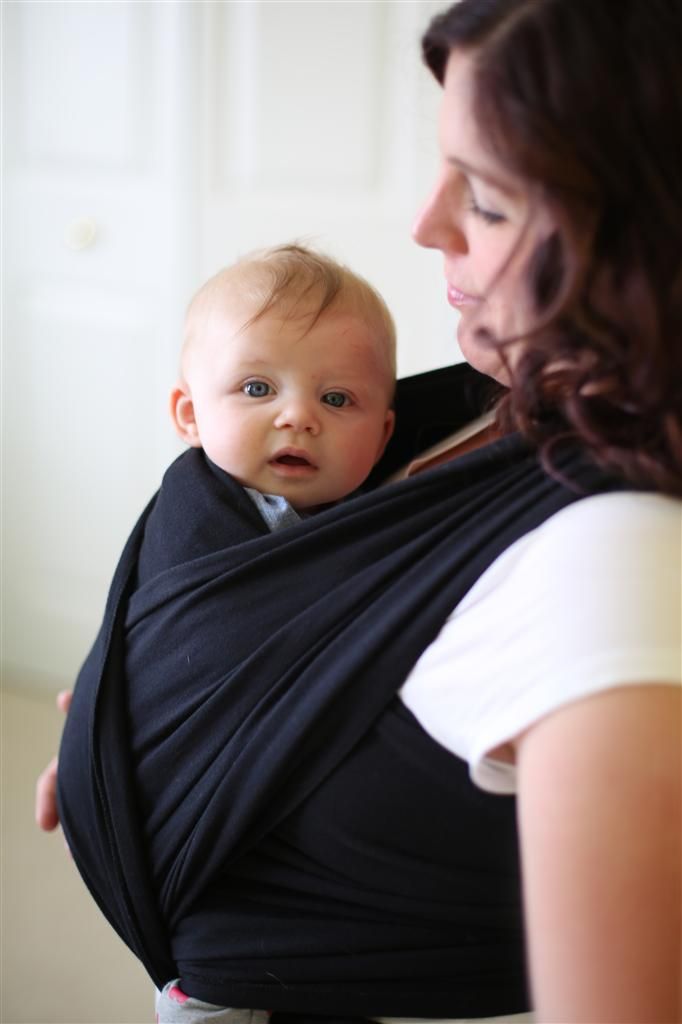 A mother holding a baby in a sling. 