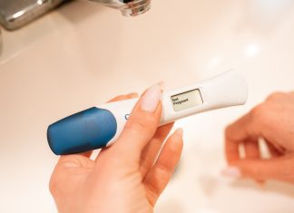 A woman holding a pregnancy test displaying the text Not Pregnant.