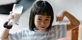 small girl holding glass of milk