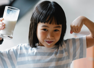 small girl holding glass of milk