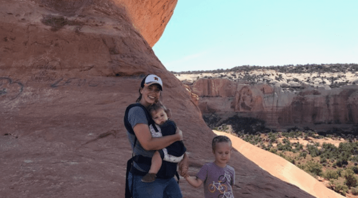 3 Things I Learned from Road Tripping Solo with My Kids A photograph of a mother holding a young girl and standing next to a young boy at a national park.