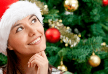 woman with Santa hat smiling thoughtfully