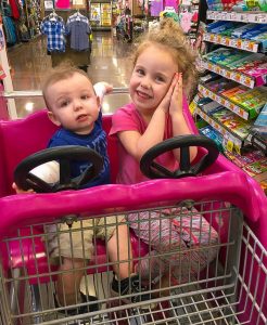 baby and preschooler in grocery cart