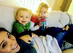 mom of littles sits with baby and toddler on couch