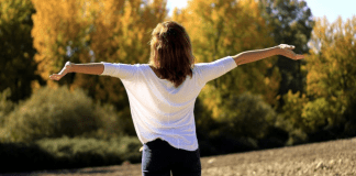Life is a Gift: An Unexpected Love Letter to 2021 A woman facing away from the camera with her arms outstretched in celebration.
