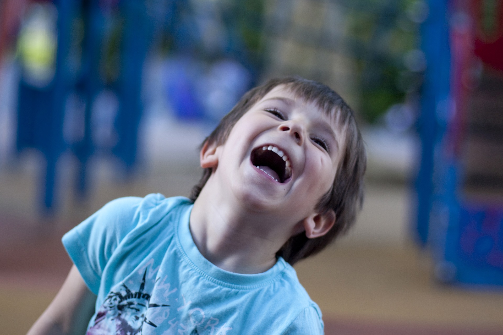 little boy laughing at a park