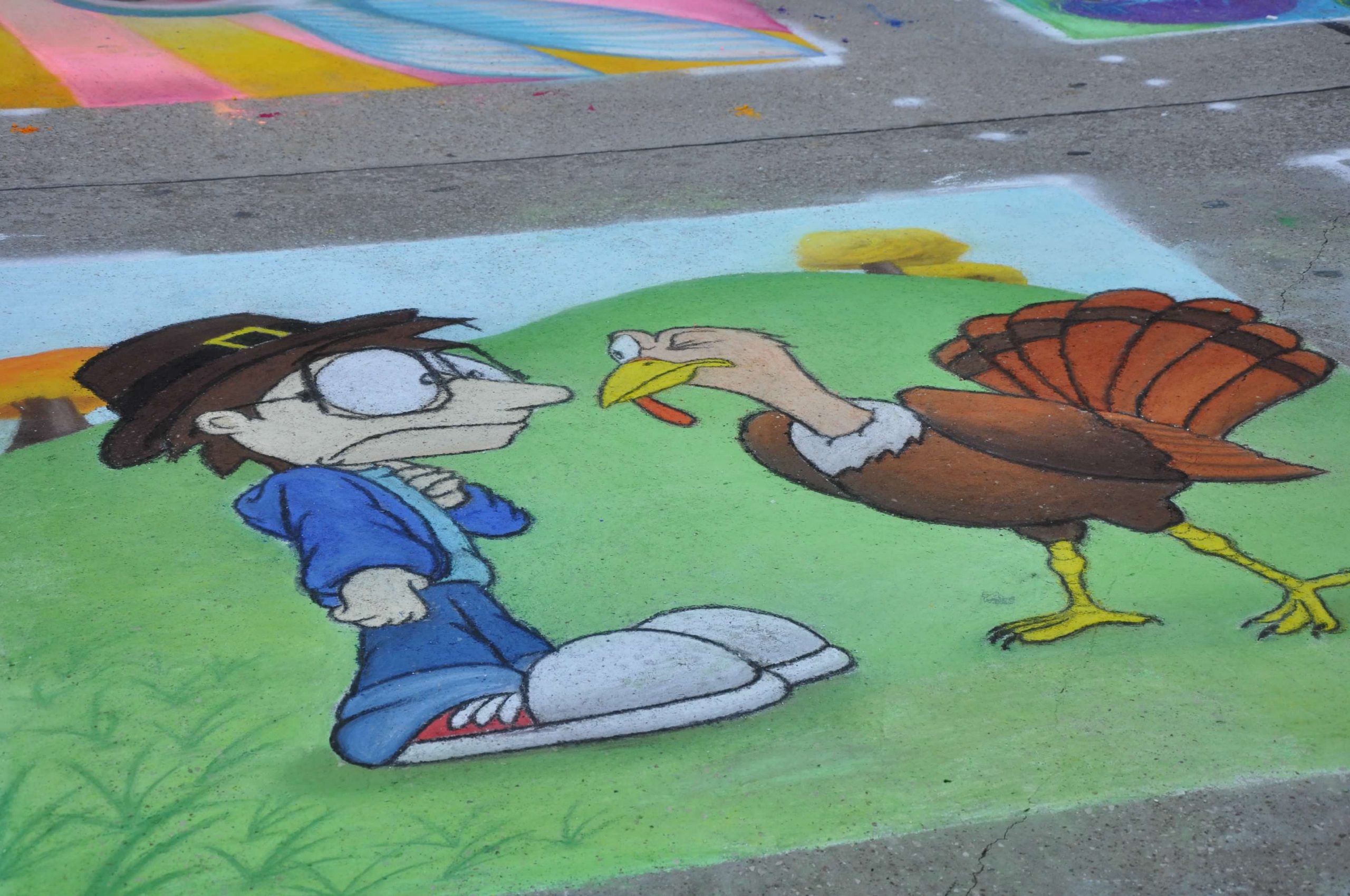 Chalk art of pilgrim in street clothes staring at a turkey