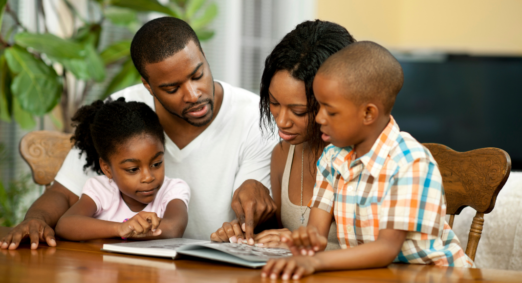 Family looks at a book for Black History Month