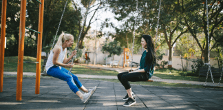 Why Making Mom Friends is Just Like Dating mom friends sit opposite each other on playground swings