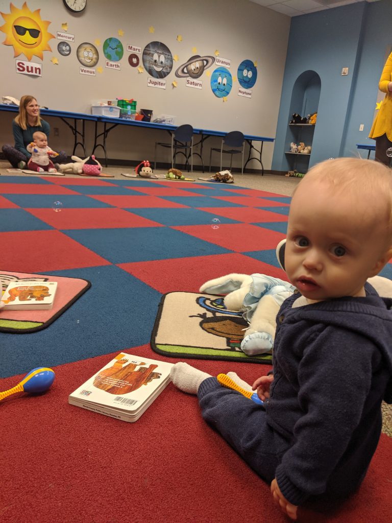baby sitting on carpet during library storytime