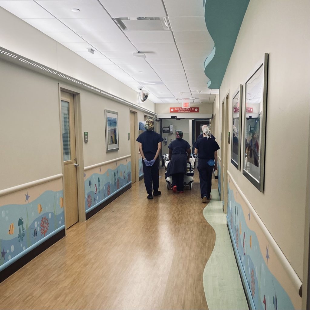 hospital team wheels a child into surgery