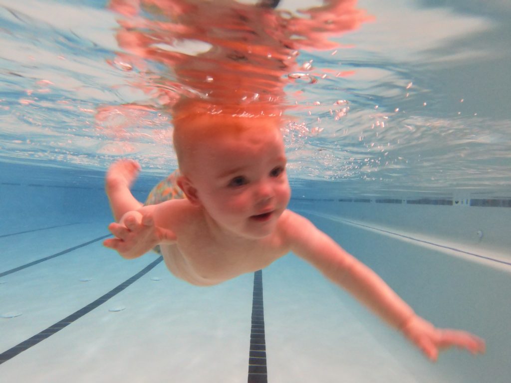 young baby under water in a pool