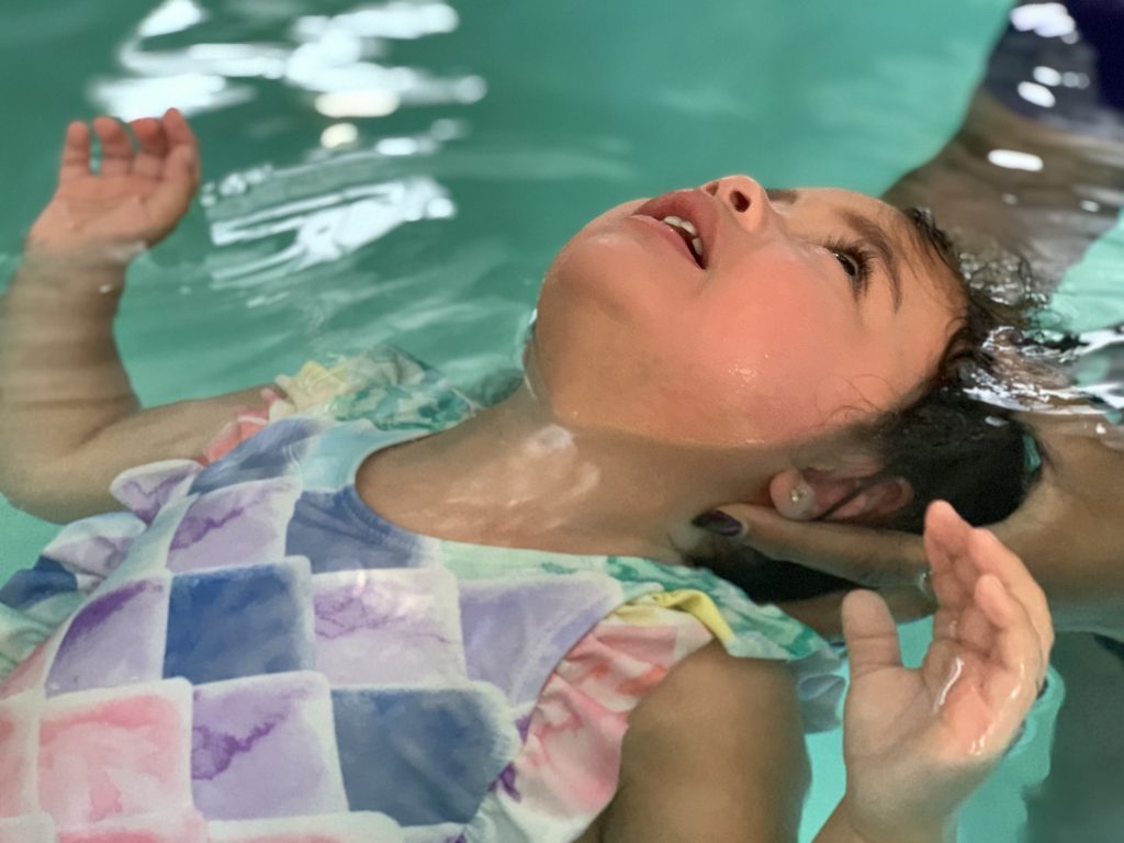 young girl floats during swim lessons