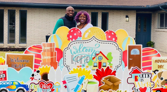 Before You Make an Offer: 3 Tips For Buying a House in Today’s Market couple who are buying a house stand in front of their home with celebratory yard signs