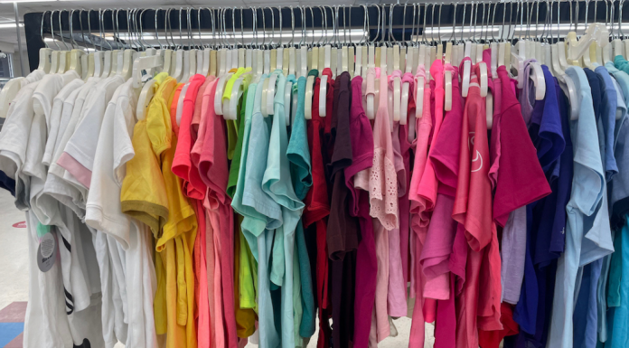 Clothing the Earth: Steps to End Clothing and Textile Waste rack of thrifted colorful shirts