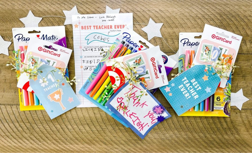a variety of gift cards, pens, and teacher appreciation items laid out on table