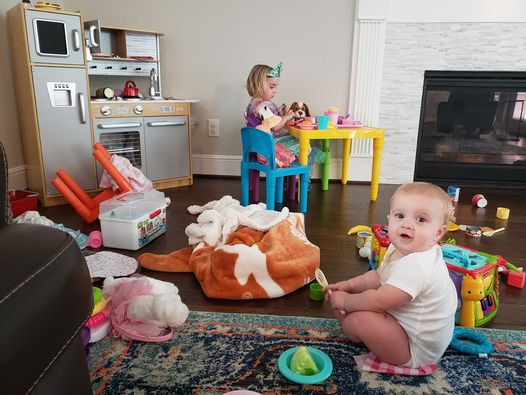 baby and toddler play in messy room 